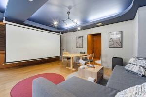 a living room with a couch and a large screen at LINKAGE STAY Chitose Funabashi in Tokyo