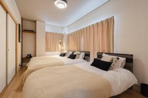 two beds in a hotel room withermottermottermott at LINKAGE STAY Chitose Funabashi in Tokyo