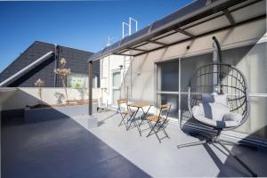 a patio with chairs and a swing on a building at LINKAGE STAY Chitose Funabashi in Tokyo