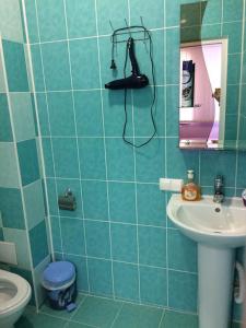 イズマイールにあるGuest House Na Suvorovaの青いタイル張りのバスルーム(シンク、シャワー付)