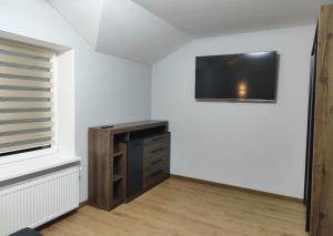 a living room with a tv on a white wall at Дім весняний in Sheremetka