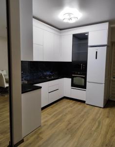 a kitchen with white cabinets and black appliances at Дім весняний in Sheremetka