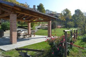 a pavilion with a picnic table in a garden at Casa Caimotta in Neive