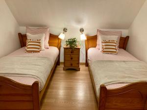two twin beds in a room with a night stand at Double J - Omaha beach in Formigny +129 photos