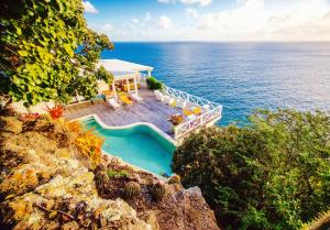 an aerial view of a house on top of the ocean at Dolcevita Cliff Private Resort by KlabHouse - Adults Only in English Harbour Town