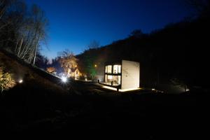 een klein huis 's nachts met de lichten aan bij Le Cube in Profondeville