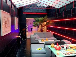 a room with couches and a table and red lights at Chambres Boufflet in Laon
