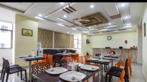 a restaurant with tables and chairs in a room at Aurum Abodes in Hyderabad +2 photos
