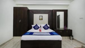 a bedroom with a large bed with blue pillows at Aurum Abodes in Hyderabad
