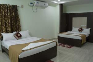 a room with two beds in a room at Aurum Abodes in Hyderabad