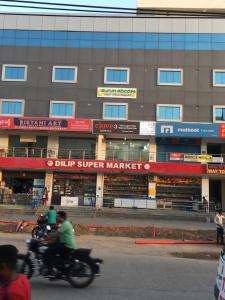two people riding motorcycles in front of a building at Aurum Abodes in Hyderabad