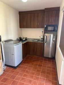 a kitchen with a refrigerator and a tile floor at Mi casa in Kathmandu