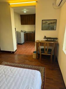 a room with a bed and a table and a kitchen at Mi casa in Kathmandu