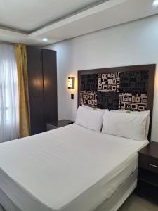 a bedroom with a large white bed in a room at Silk Mbare Guest House in Manzini +15 photos