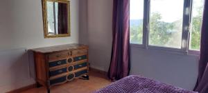 a bedroom with a dresser and a mirror and a window at CAP AZUR ILE du LEVANT in Île du Levant