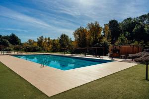 a large swimming pool in a yard with trees at Camping El Pasqualet in Caldes de Montbui +18 photos
