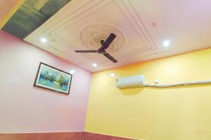a ceiling with a fan and a painting on a wall at Shree Ladli Ju Dham in Vrindāvan
