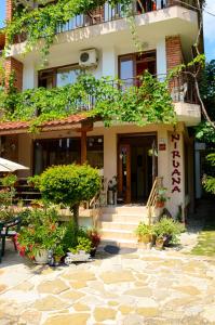 a building with plants and flowers in front of it at Nirvana Guest House in Nesebar