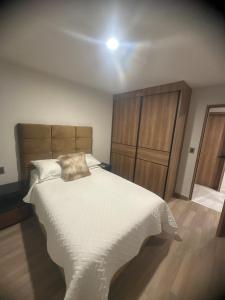a bedroom with a large white bed with a wooden headboard at Santa Fe Dorado Atardecer in Atlacholoaya +27 photos