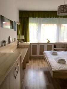 a kitchen with a table and a large window at Mikes Apartman in Szekszárd