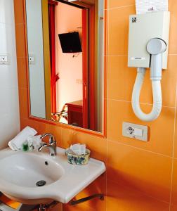 bagno con lavandino e specchio di Hotel Ristorante Casa Rossa ad Alba Adriatica