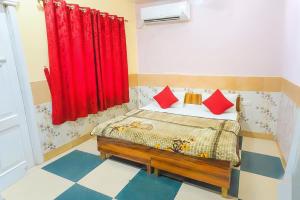 a bedroom with a bed with red curtains at Shree Ladli Ju Dham in Vrindāvan