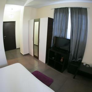 AfumaţiにあるGrande Palaceのベッドルーム(ベッド1台、テレビ、カーテン付)
