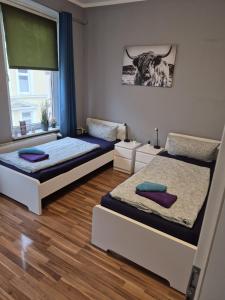 a bedroom with two beds and a cow picture on the wall at Stadtnah an der Förde 7502 E in Flensburg