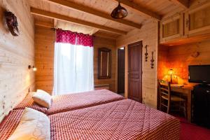 a bedroom with a bed and a window and a desk at Hôtel Le Bellevue in Thollon +24 photos