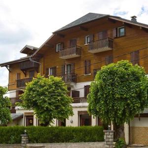 a large wooden building with two trees in front of it at Hôtel Le Bellevue in Thollon