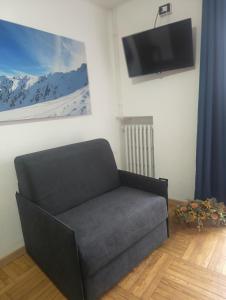 a black couch sitting in a room with a tv at Chalet Monte Nebius in Vinadio