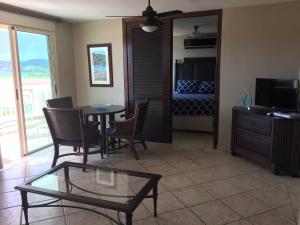 a living room with a table and chairs and a television at Villa 2302 Costa Bonita Beach Resort in Culebra