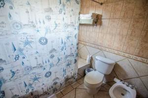 a bathroom with a toilet and a shower curtain at Villa 2302 Costa Bonita Beach Resort in Culebra +3 photos