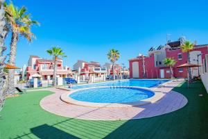 a swimming pool in a resort with palm trees and houses at Altos Bahia Magic in Torrevieja