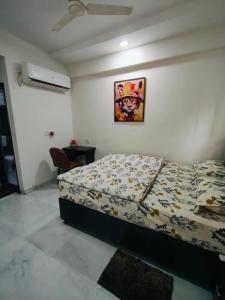 a bedroom with a bed and a picture on the wall at Staywise in Indore