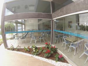 a patio with tables and chairs in a building at Hotel Aero Park e Estacionamento in Londrina