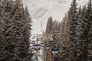 a ski lift with snow covered trees on a mountain at JONI Apartments Berwang in Berwang