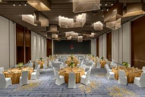 a large banquet hall with tables and white chairs at Deqing Marriott Hotel in Huzhou +51 photos