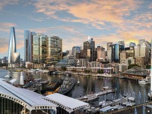 a view of a city with boats in a harbor at Novotel Sydney Darling Harbour in Sydney