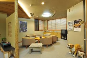 une salle d'attente avec un chien assis au milieu dans l'établissement Nakayasu Ryokan, à Kanazawa