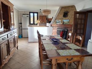 a kitchen with a table with chairs and a fireplace at La petite Ginette in Serres