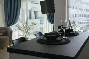 a dining table with two glasses and a bowl and plate at Waves 60 Infinity in Mamaia Sat/Năvodari +16 photos