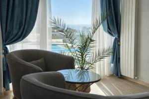 a living room with two chairs and a table with a plant at Waves 60 Infinity in Mamaia Sat/Năvodari