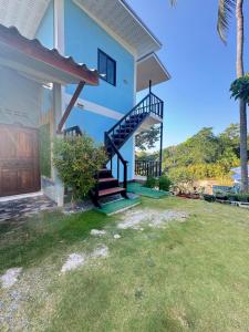 a house with a staircase in front of a yard at Baan phuwamin in Ko Lanta