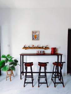 a table with stools in front of a white wall at Joy Private Pool Villa in Kuta