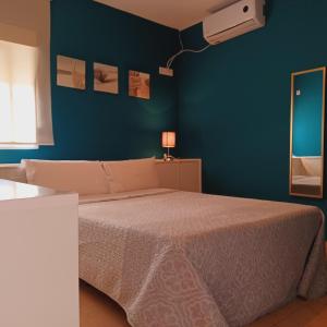 a bedroom with a bed and a blue wall at C&H Aravaca Garden in Madrid