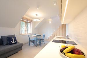 a kitchen and living room with a bowl of fruit on the counter at Dom Wakacyjny Solano in Ustka