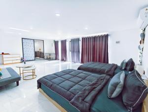 a bedroom with a large bed and a living room at Joy Private Pool Villa in Kuta