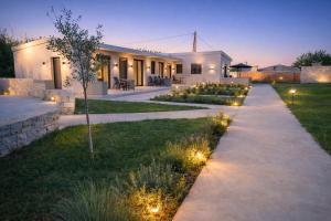 a pathway leading to a house with lights in the grass at Sweven boutique apartments in Souda