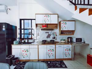a kitchen with white cabinets and a counter top at Joy Private Pool Villa in Kuta
